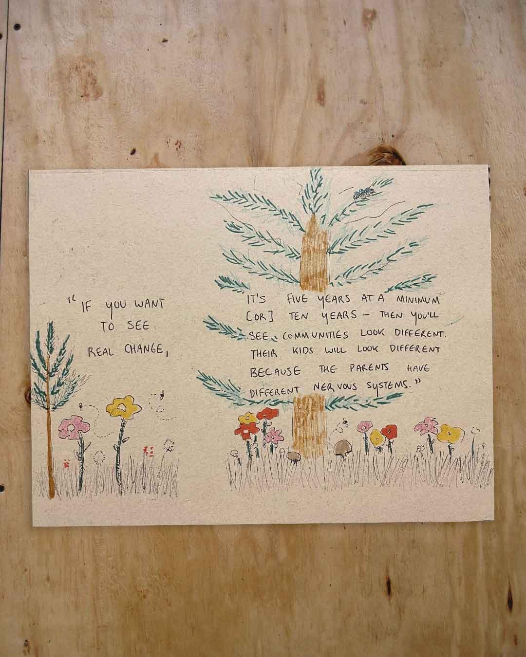 Hand-drawn illustration on textured paper: a large green tree with a brown trunk above a row of colorful flowers, surrounding a handwritten quote about real change taking 5–10 years and how communities and children look different when parents have different nervous systems; photographed on a wooden tabletop.